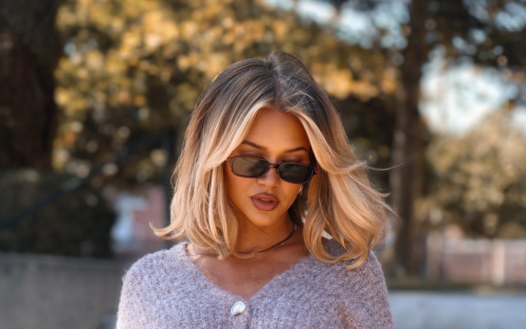 Moderna ženska frizura srednje dužine sa plavim pramenovima i volumenom