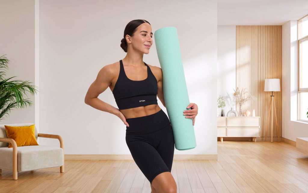 Zaboravite na trenera: Ovih 7 vježbi zatežu cijelo tijelo kod kuće Zadovoljna žena s prostirkom za vježbanje kod kuće, priprema za trening za cijelo tijelo.