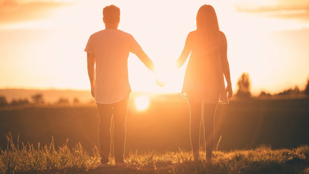 Par koji se drži za ruke tokom zalaska sunca